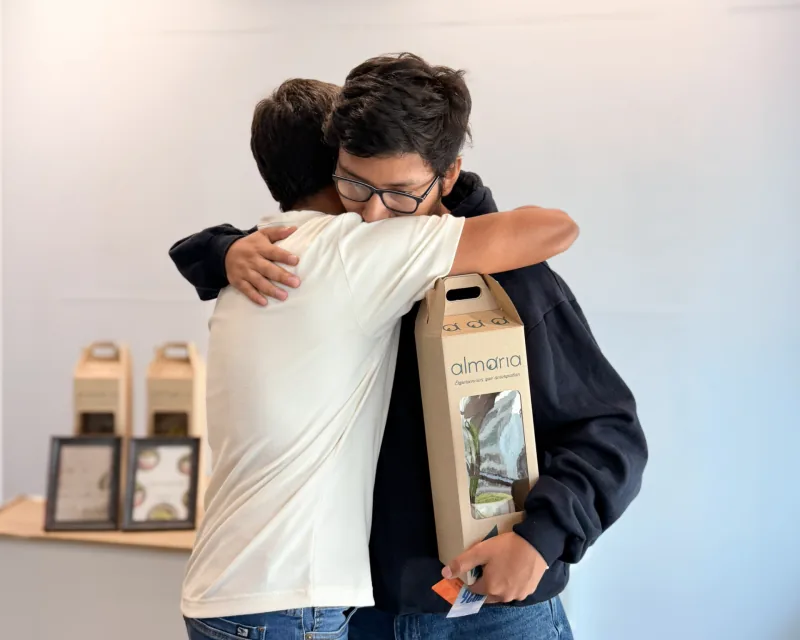 Abrazo entre compañeros con regalo corporativo ALMARIA